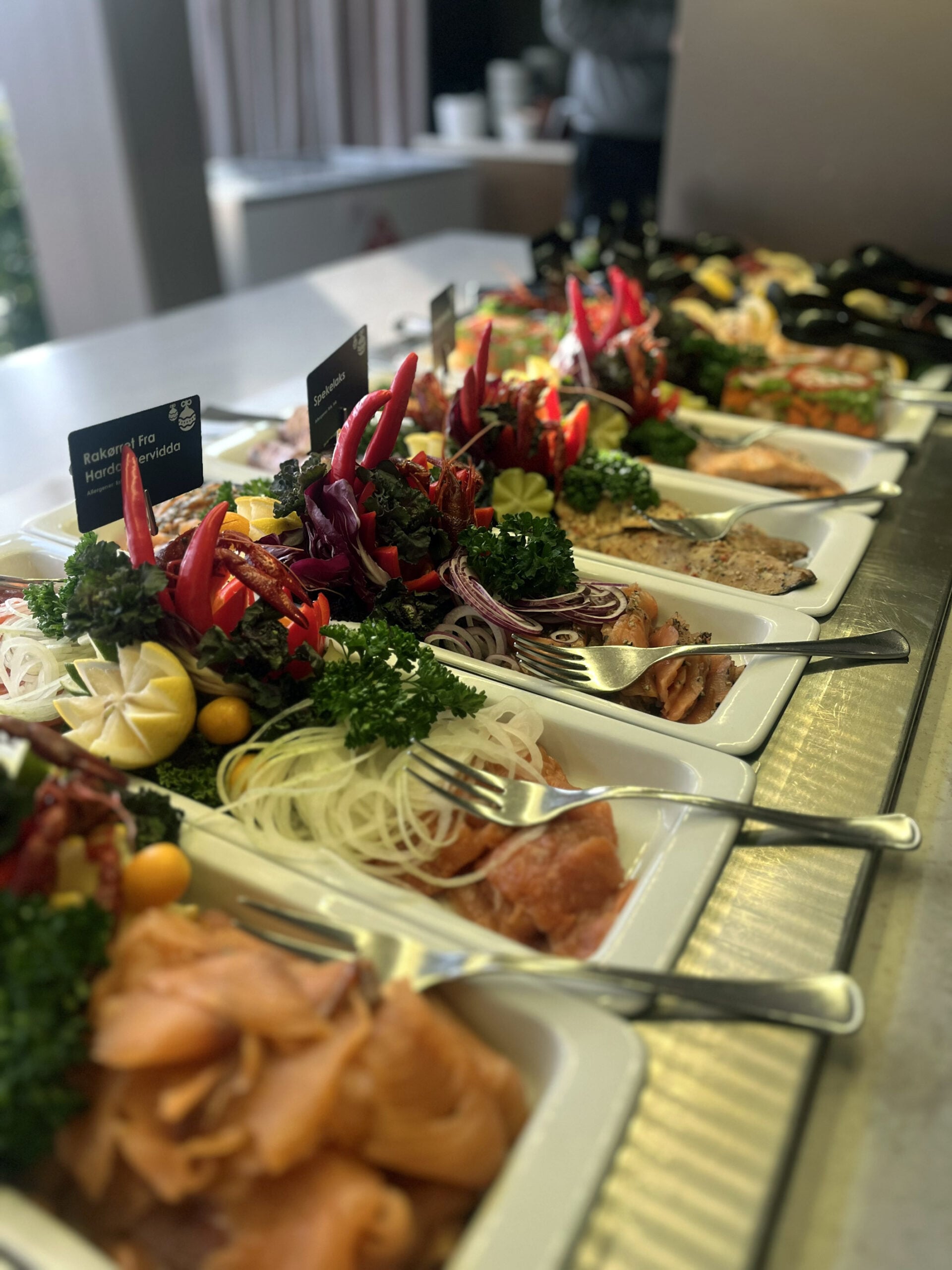 Variert fiskebord med friske urter, grønnsaker og sitrusfrukter til pynt. Fargerik servering av sjømat.